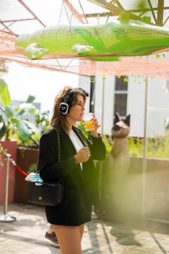 Silentdisco op dame har hoofd die een biertje drinkt