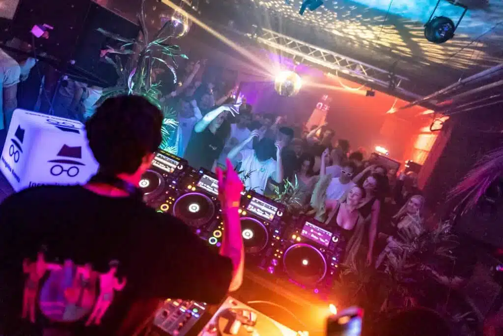 Een dj achter een draaitafel van het merk Pioneer